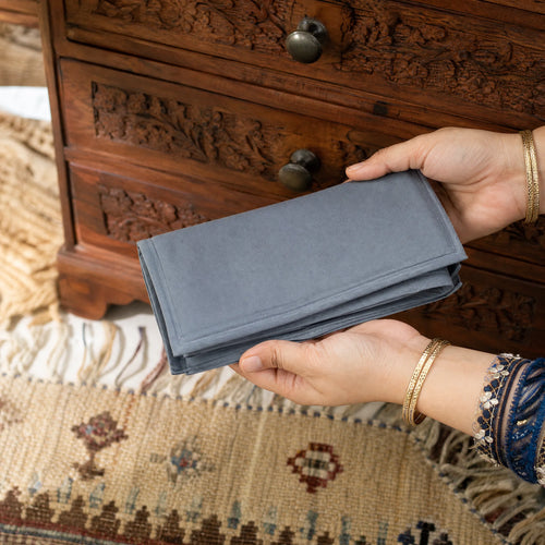 Box folded flat beside a hand showing compact size